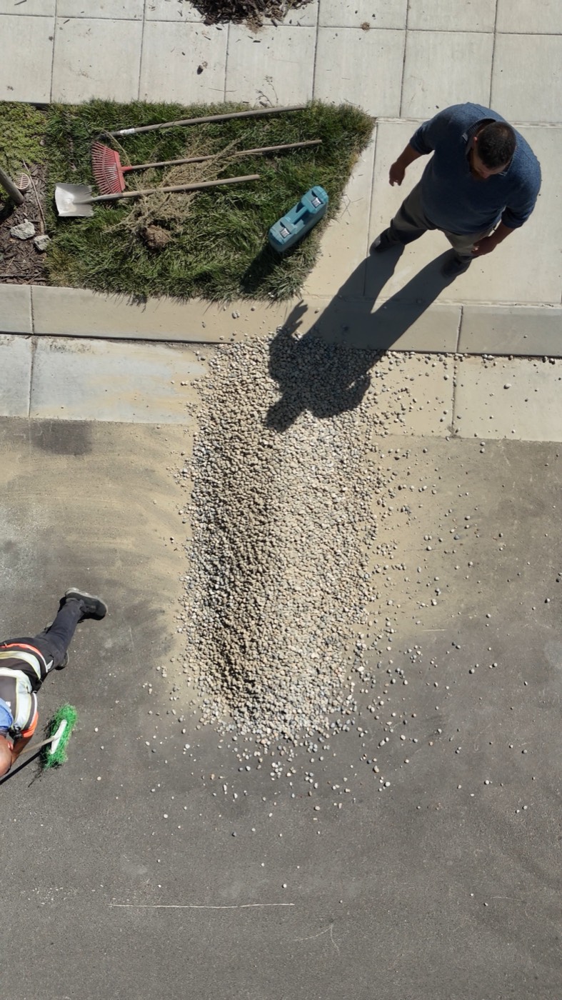 Top-down view of a gravel pile delivered onto a residential driveway