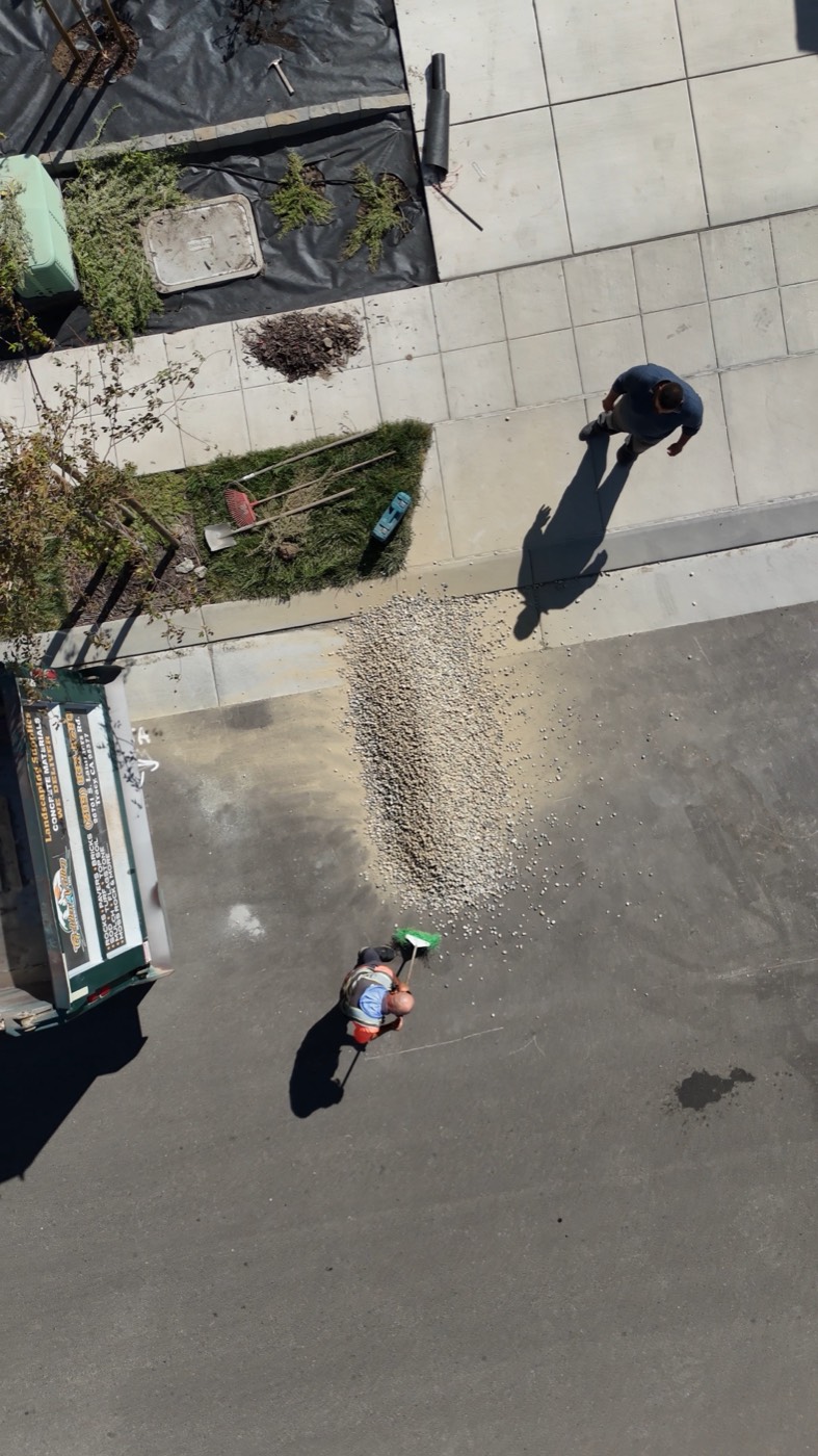 Crew spreading delivered gravel across a driveway