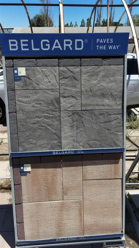 Close-up of premium large-format paver samples with contemporary textures, set against a clear sky backdrop.