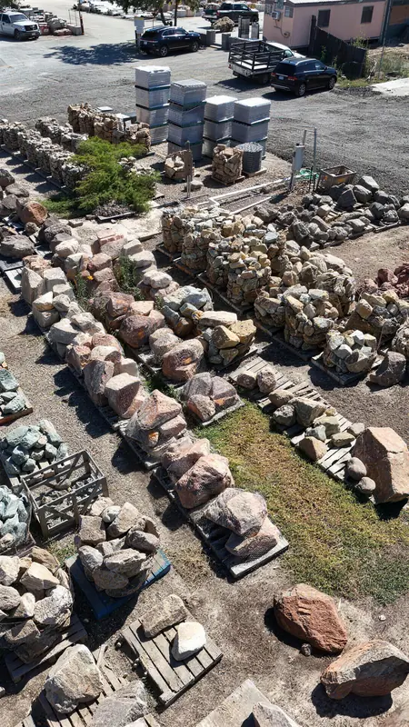 Natural boulders displayed in our outdoor showroom area, surrounded by complementary landscaping elements.